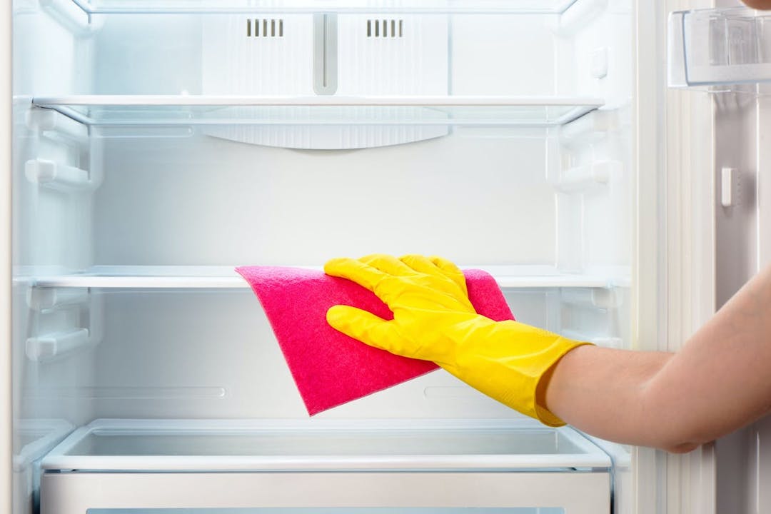 An arm cleaning out a refrigerator 