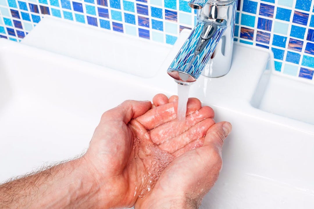 Hands being washed in a sink