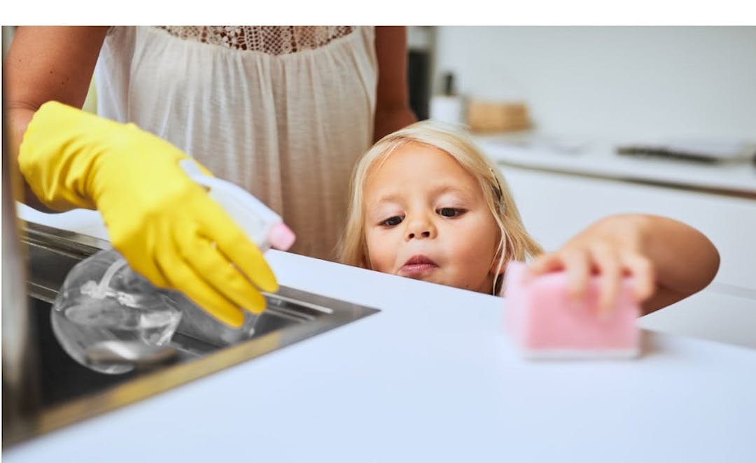 A child cleaning a counter top